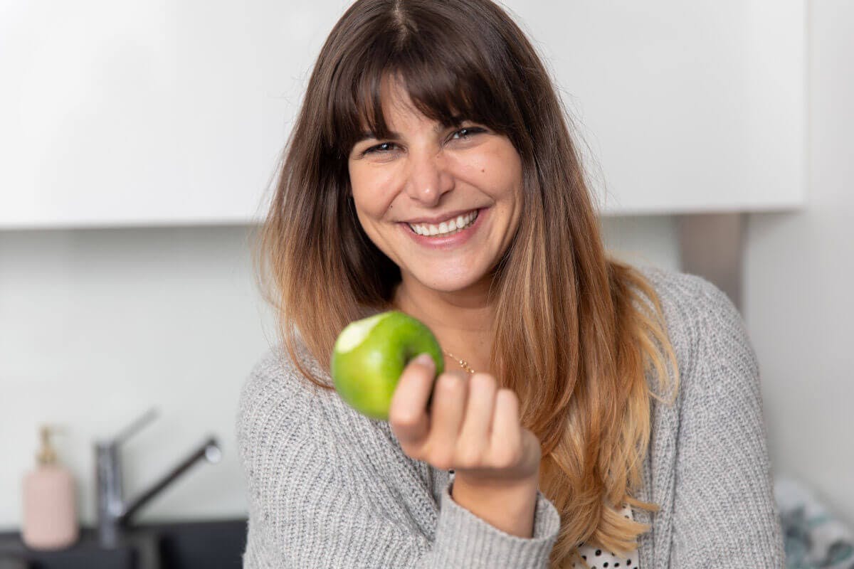 Frau mit grünem Apfel in der Hand