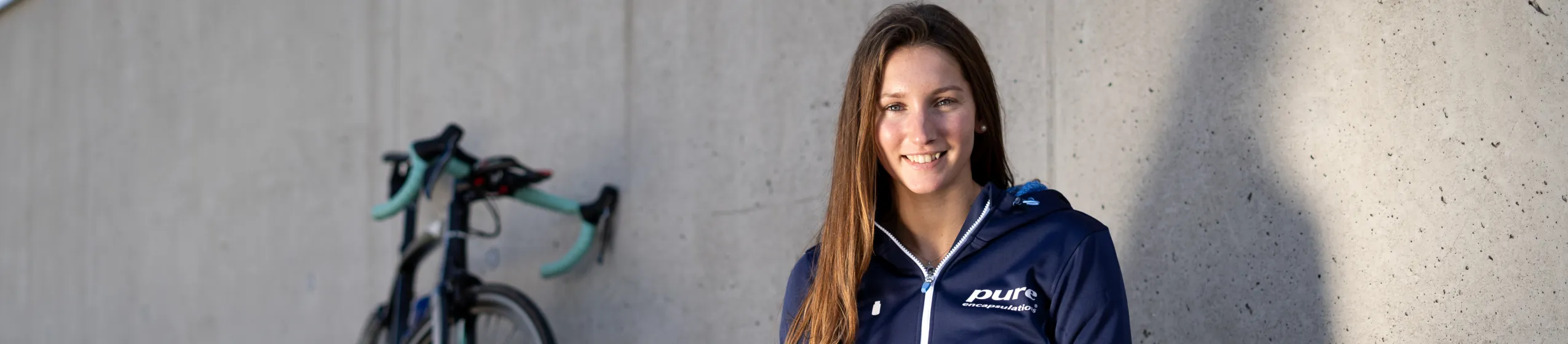 Therese Feuersinger  sitzt am Boden neben ihrem Fahrred