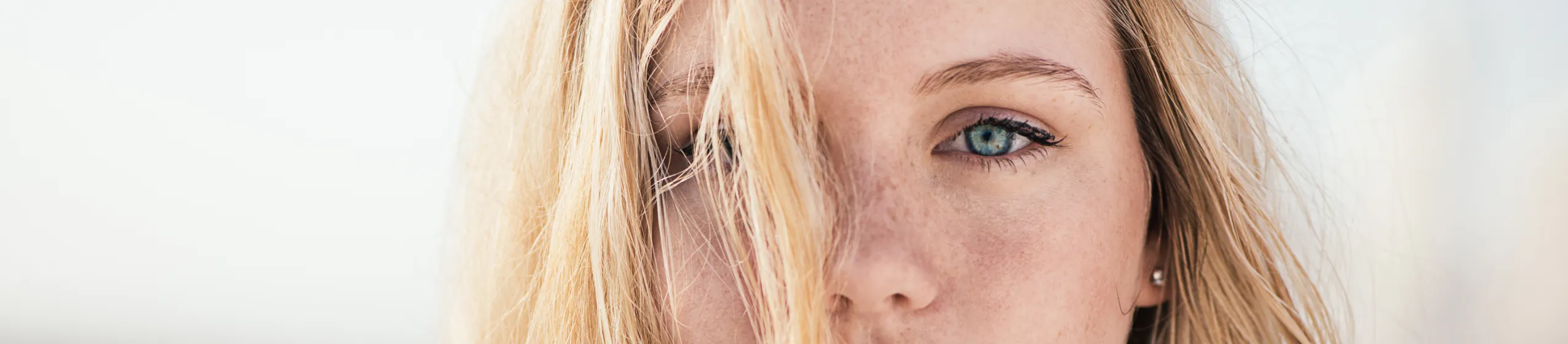 Blonde Frau mit Strähne im Gesicht