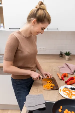 Immunsystem Gemüse Küche kochen Frau jung lächeln blond weiß Gesunde Ernährung Paprika orange rot Hand