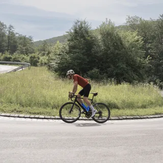 Mann auf Rennrad fährt auf Straße