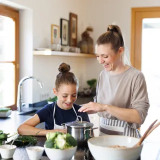 Frau kocht mit Sohn in der Küche