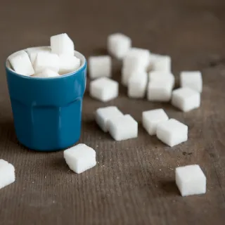 Zuckerwürfel in einem blauen Becher