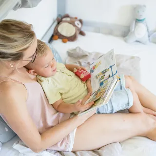 Mutter liest Kind etwas vor