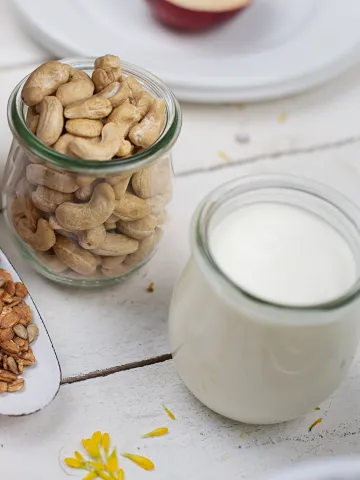 Ein Glas Milch, Haferflocken, Nüsse und Äpfel