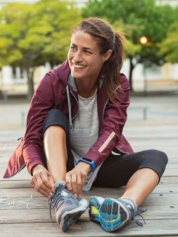Frau richtet beim Sport ihre Sneaker
