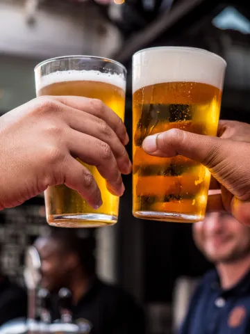 Zwei Männer stoßen mit Biergläsern an