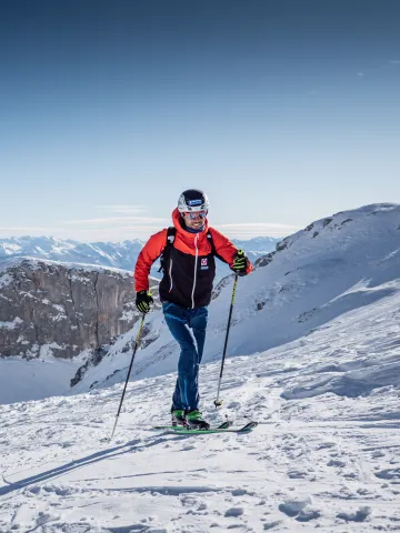 Jakob Herrmann mit Ski und Stecken am Berg
