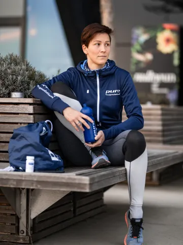 Eine Frau mit Trinkflasche macht eine Pause