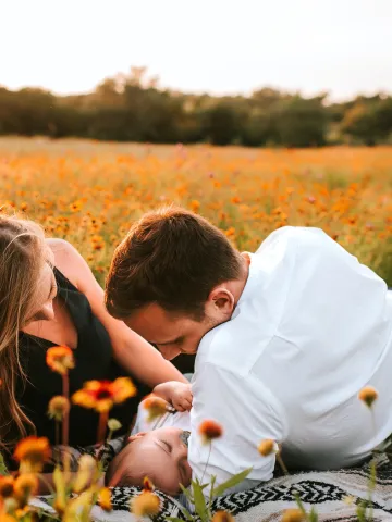 Paar mit Baby auf Blumenwiese