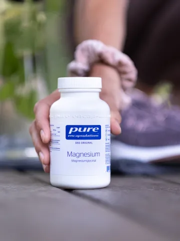 Hand greift zu Magnesium-Bottle von Pure Encapsulations