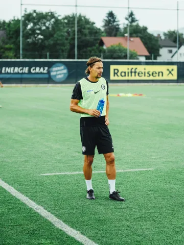 Fußballer von SK Sturm mit Trinkfalsche am Fußballfeld