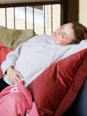Frau hält sich entspannt den Bauch