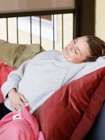 Frau hält sich entspannt den Bauch