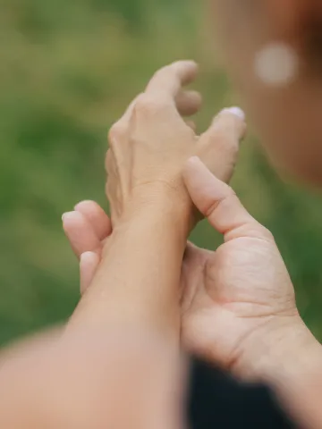 Eine Hand umfasst das Handgelenk der anderen