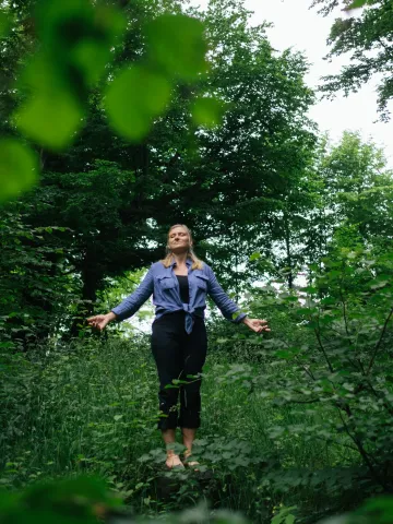 Frau im Wald beim entspannten Waldbaden