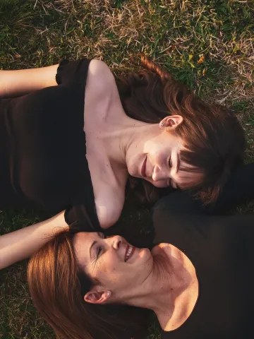 Zwei Frauen liegen auf einer Wiese