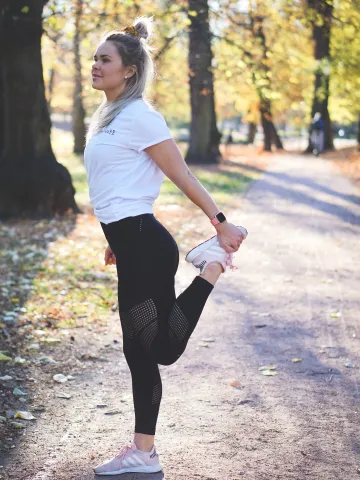 Frau dehnt sich vor dem Laufen im Park