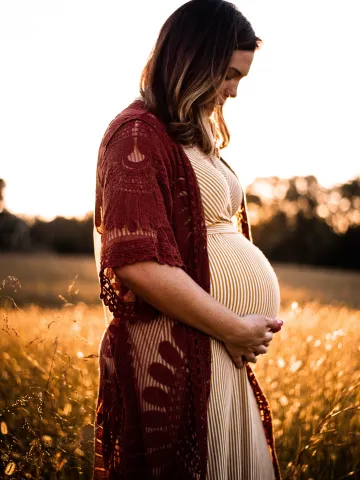 Eine schwangere Frau hält sich den Babybauch