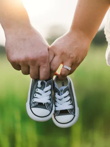Paar hält Babyschuhe in der Hand