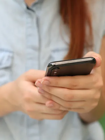 Frau hält ihr Smartphone in der Hand