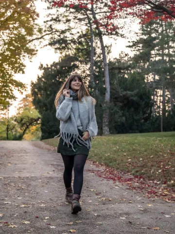 Frau spaziert im Herbst durch den Park