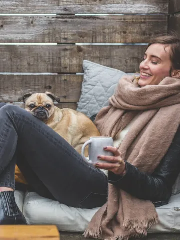 Eine Frau und ein Mann sitzen im Herbst warm eingepackt draußen