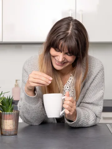 Frau mit einer Teetasse in der Küche
