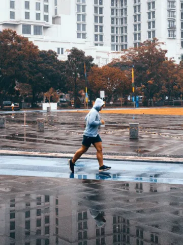 Mann mit grauem Kapuzenpullover joggt
