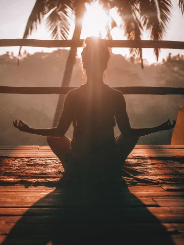Frau meditiert in der Abendsonne