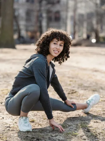 Frau dehnt ihre Beine im Sportoutfit