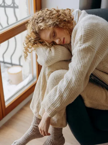 Eine Frau schläft auf einem Sessel