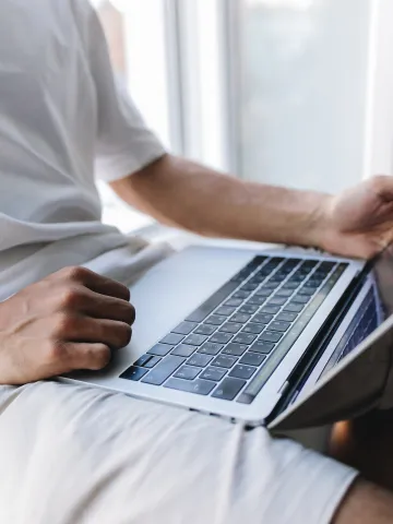 Mann mit Laptop am Schoß