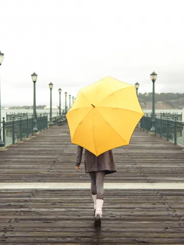 Frau mit gelben Regenschirm
