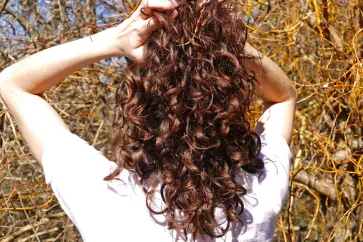 Frau hält ihren Locken hoch