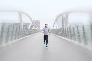 Pure Athlet Aaron Gruen läuft auf einer Brücke