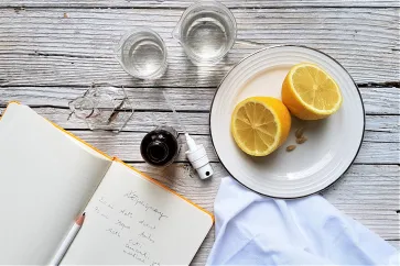 Wasser, eine Sprühflasche und Zitronen