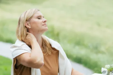 Frau hält sich den Nacken