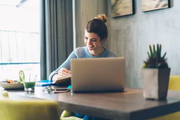 Frau sitzt vor dem Laptop