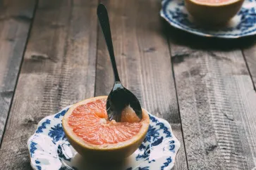 Graipfruit mit Löffel auf einem Teller