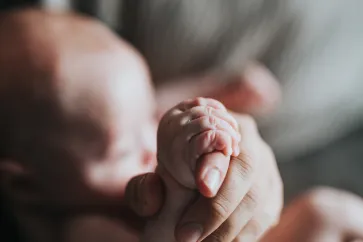 Babyfinger und Hand der Eltern