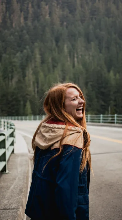 victoria quirk c6KpSFyJ6O8 unsplash rothaarig junge Frau lachen Herbst Wald Brücke Straße Natur outdoor draußen Jacke wandern langes Haar lange Haare