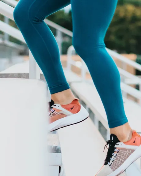 Frauenbeine in Laufkleidung die Stiegen hinauf laufen