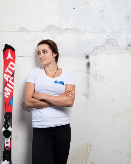 Chiara Mair lehnt neben Atomic Ski an der Wand