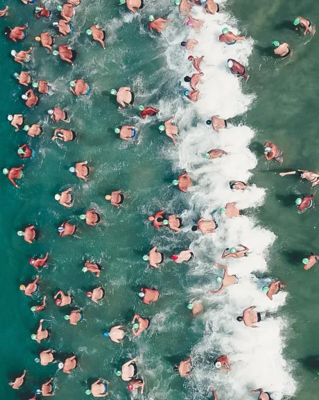 Vogelperspektive von Triathleten beim Start ins Wasser