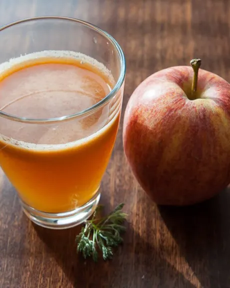 Glas Apfelsaft mit Apfel daneben