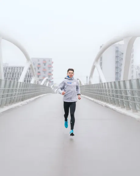 Pure Athlet Aaron Gruen läuft auf einer Brücke