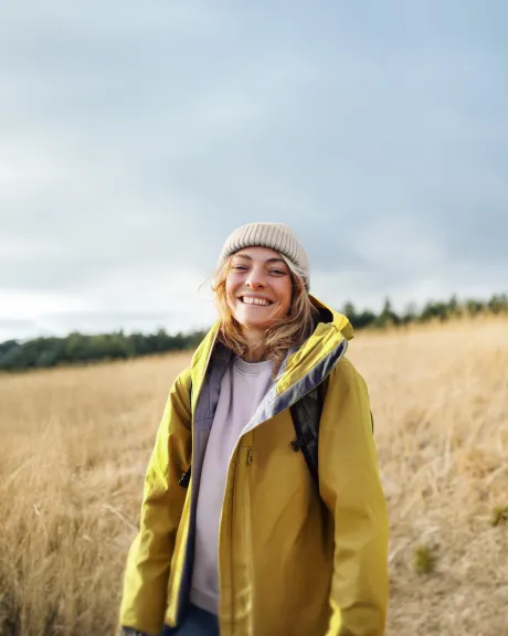 Frau steht in einem herbstlichen Feld