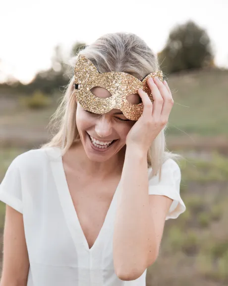 Frau mit Katzenmaske lächelt