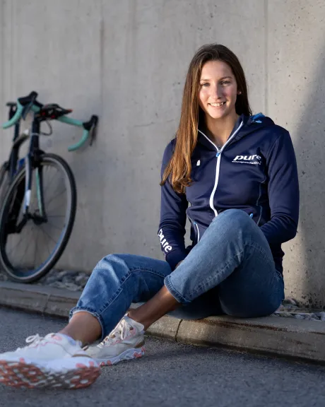 Therese Feuersinger  sitzt am Boden neben ihrem Fahrred